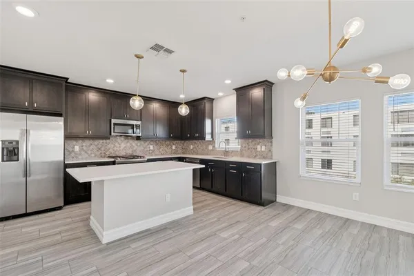 a kitchen with stainless steel appliances a sink stove and microwave