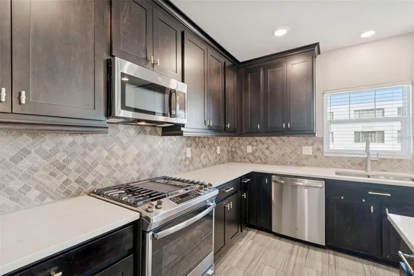 a kitchen with stainless steel appliances a sink stove and refrigerator