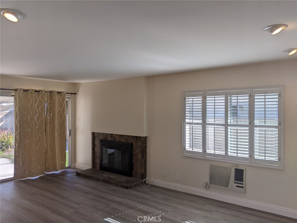 202 South Agate Street Anaheim, CA 92804 - Photo 3 of 15 an empty room with wooden floor fireplace and windows