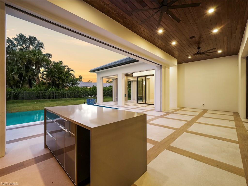 2115 Crayton Road Naples, FL 34102 - Photo 3 of 9 a dinning table and chairs in patio with green space