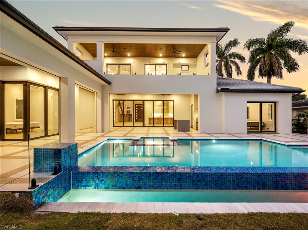 2115 Crayton Road Naples, FL 34102 - Photo 5 of 9 a front view of a house with swimming pool having outdoor seating