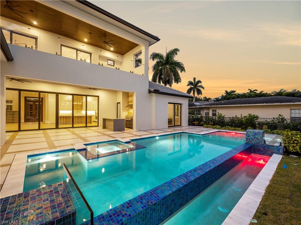 2115 Crayton Road Naples, FL 34102 - Photo 6 of 9 a swimming pool with outdoor seating and yard