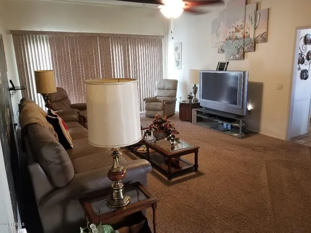 a living room with furniture a window and a flat screen tv