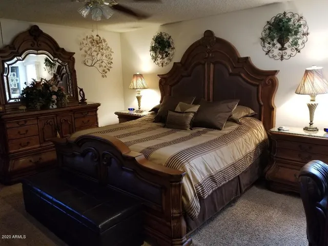 a bedroom with a bed and a painting on the wall