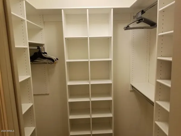 a view of walk in closet with empty racks