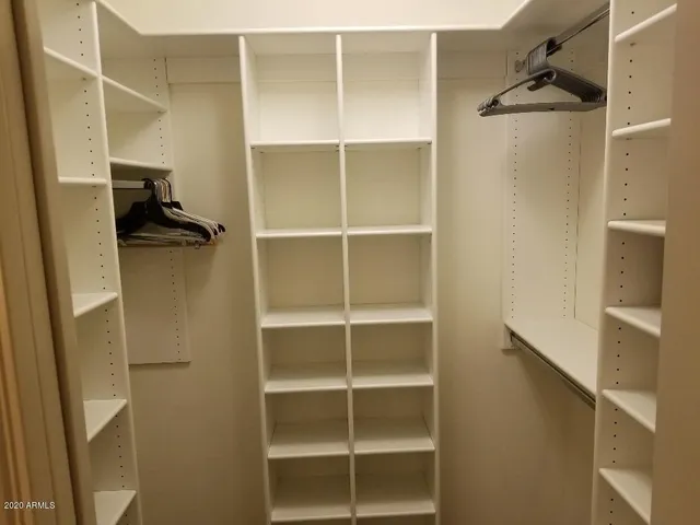 a view of walk in closet with empty racks