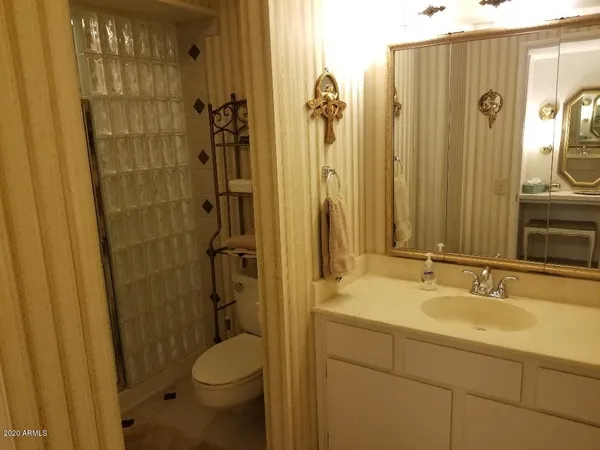 a bathroom with a granite countertop sink toilet and shower