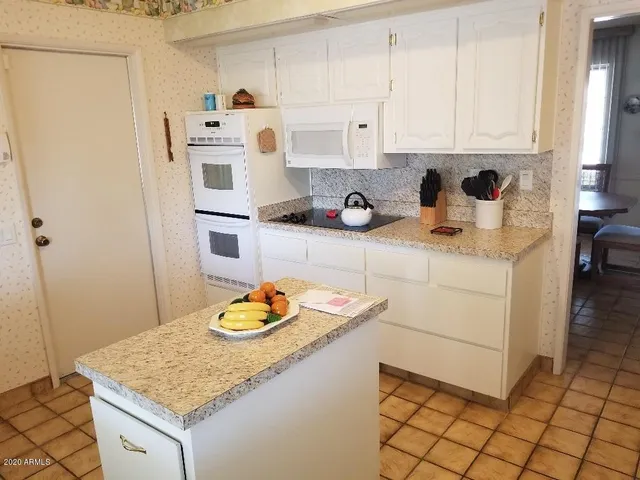 a kitchen with stainless steel appliances granite countertop a sink stove and white cabinets