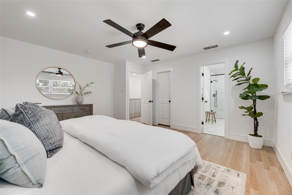 9662 Angleridge Road Dallas, TX 75238 - Photo 21 of 30 a bedroom with a bed and a chandelier