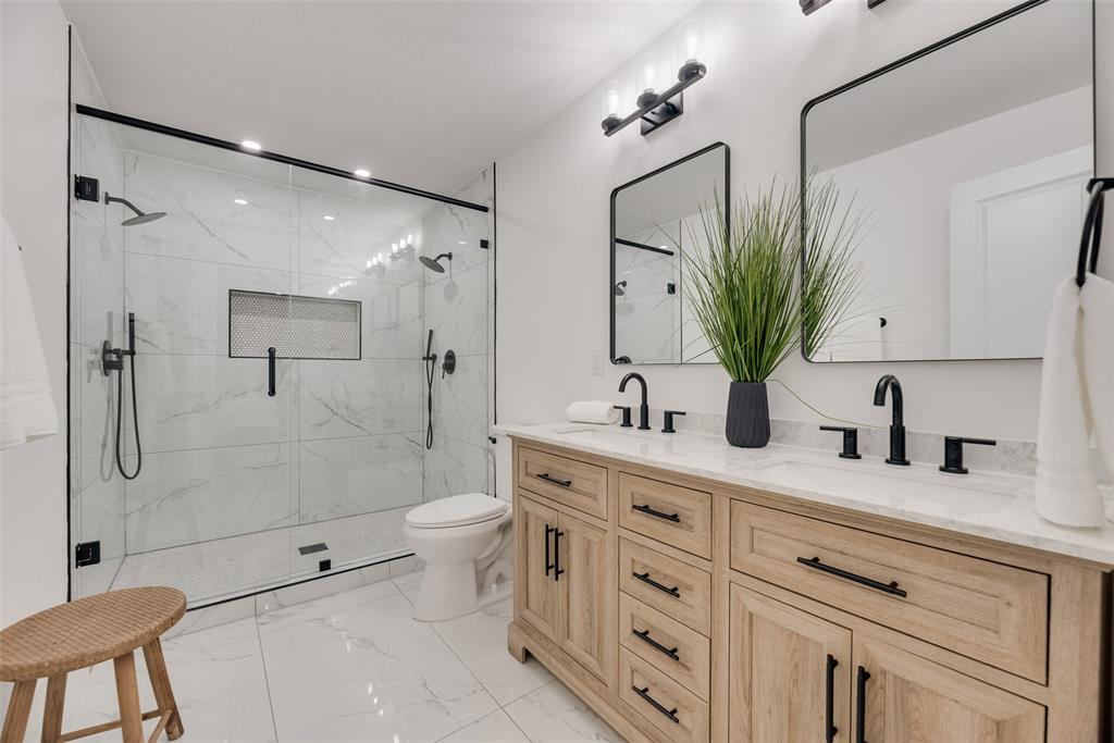 9662 Angleridge Road Dallas, TX 75238 - Photo 22 of 30 a bathroom with a double vanity sink toilet and shower