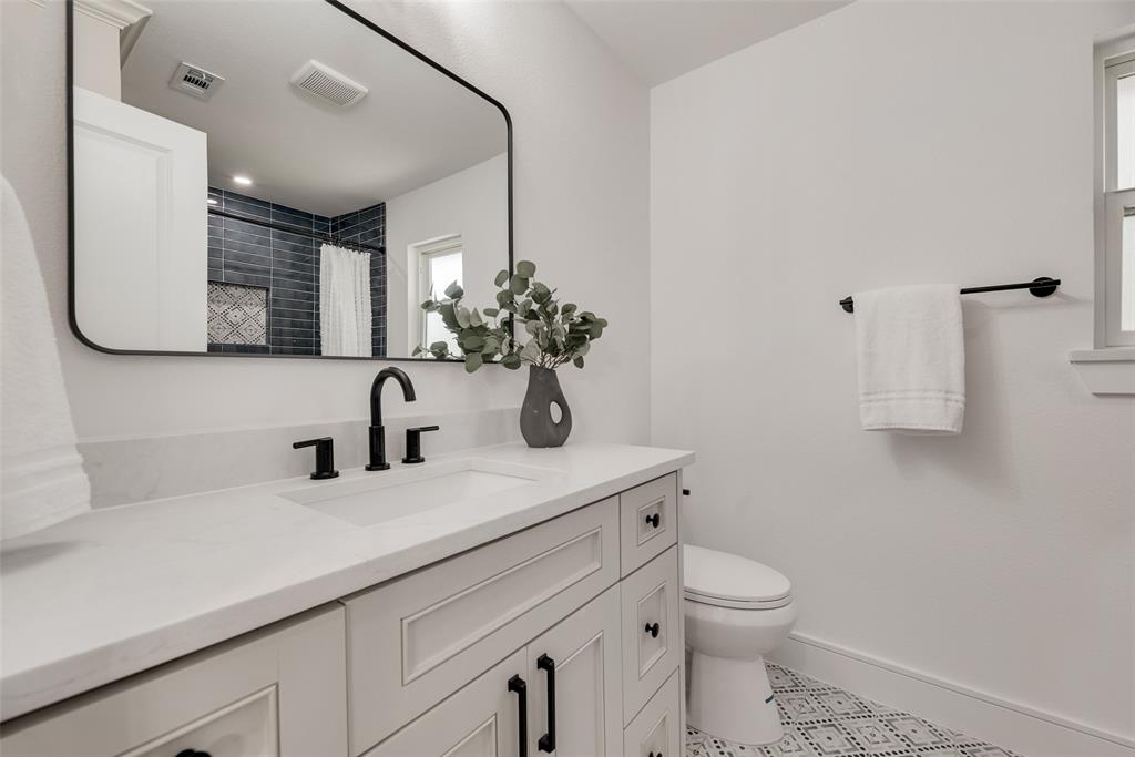 9662 Angleridge Road Dallas, TX 75238 - Photo 26 of 30 a bathroom with a sink a toilet and mirror