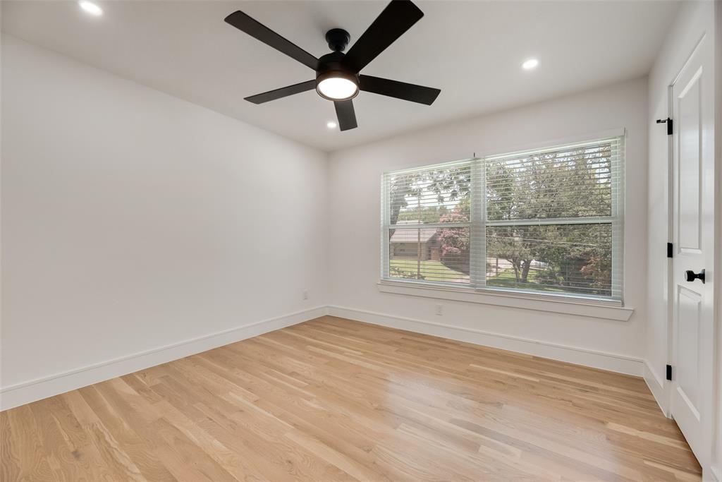 9662 Angleridge Road Dallas, TX 75238 - Photo 27 of 30 an empty room with wooden floor and windows