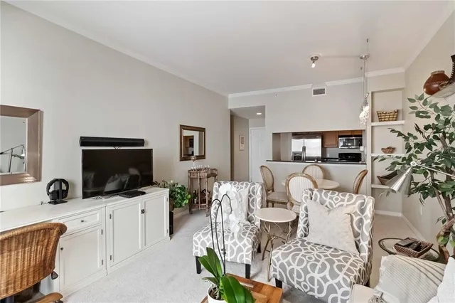a kitchen with stainless steel appliances a dining table chairs and a refrigerator