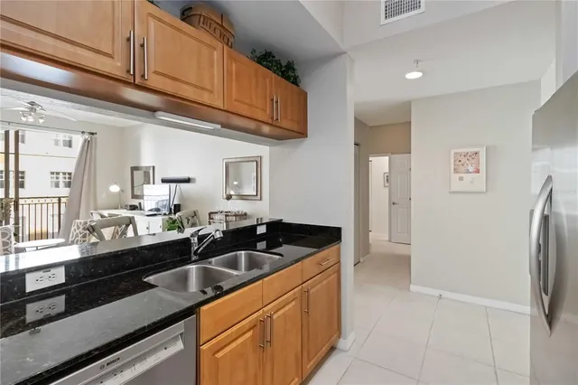 a kitchen with stainless steel appliances granite countertop a refrigerator and a sink