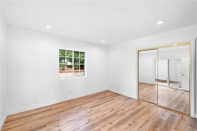 an empty room with wooden floor and window