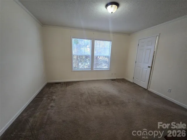 a view of wooden fence and trees in the background