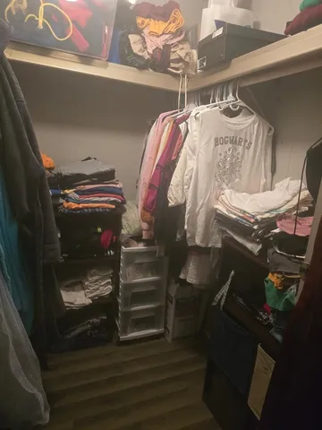 a view of walk in closet with clothes and shoes