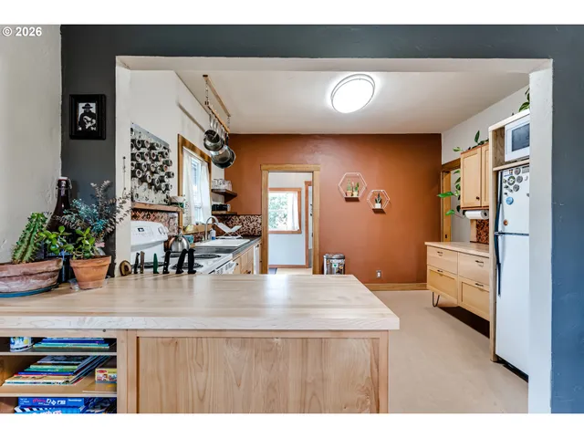 a kitchen with stainless steel appliances kitchen island granite countertop a refrigerator a stove a oven with white countertops