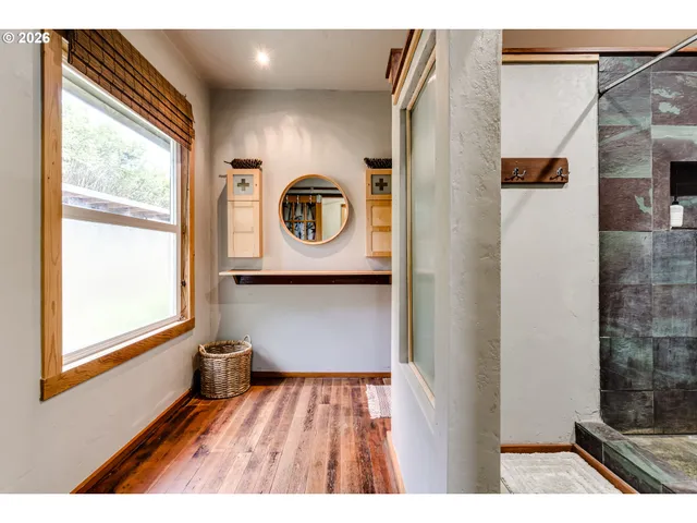 a view of a bedroom with a window and wooden floor