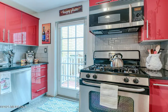 a kitchen with stainless steel appliances granite countertop a stove and a microwave