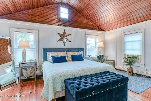 a bedroom with a bed and a table with wooden floor