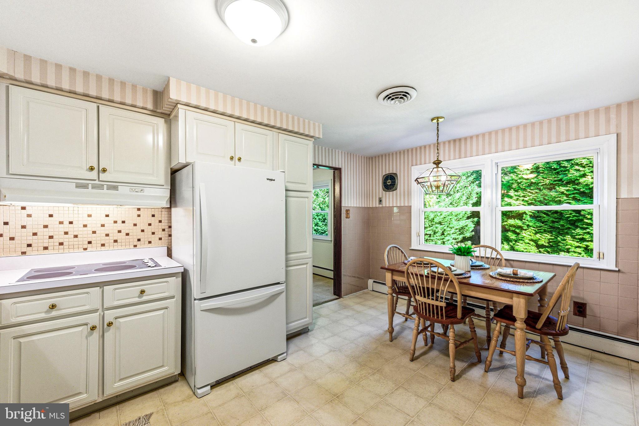 210 Cooper Drive Wallingford, PA 19086 - Photo 13 of 47 a white kitchen with sink table and chairs