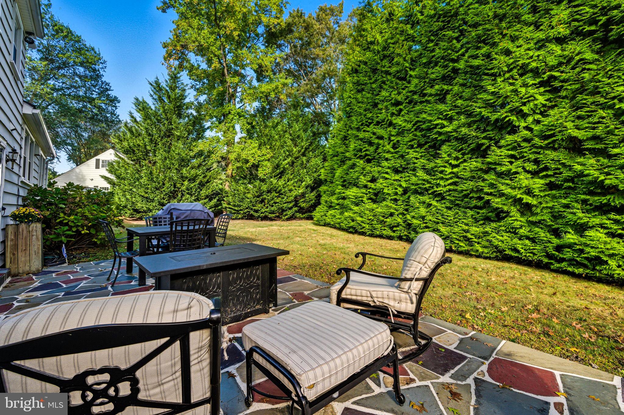 210 Cooper Drive Wallingford, PA 19086 - Photo 35 of 47 a view of a patio with table and chairs and potted plants with wooden floor and fence