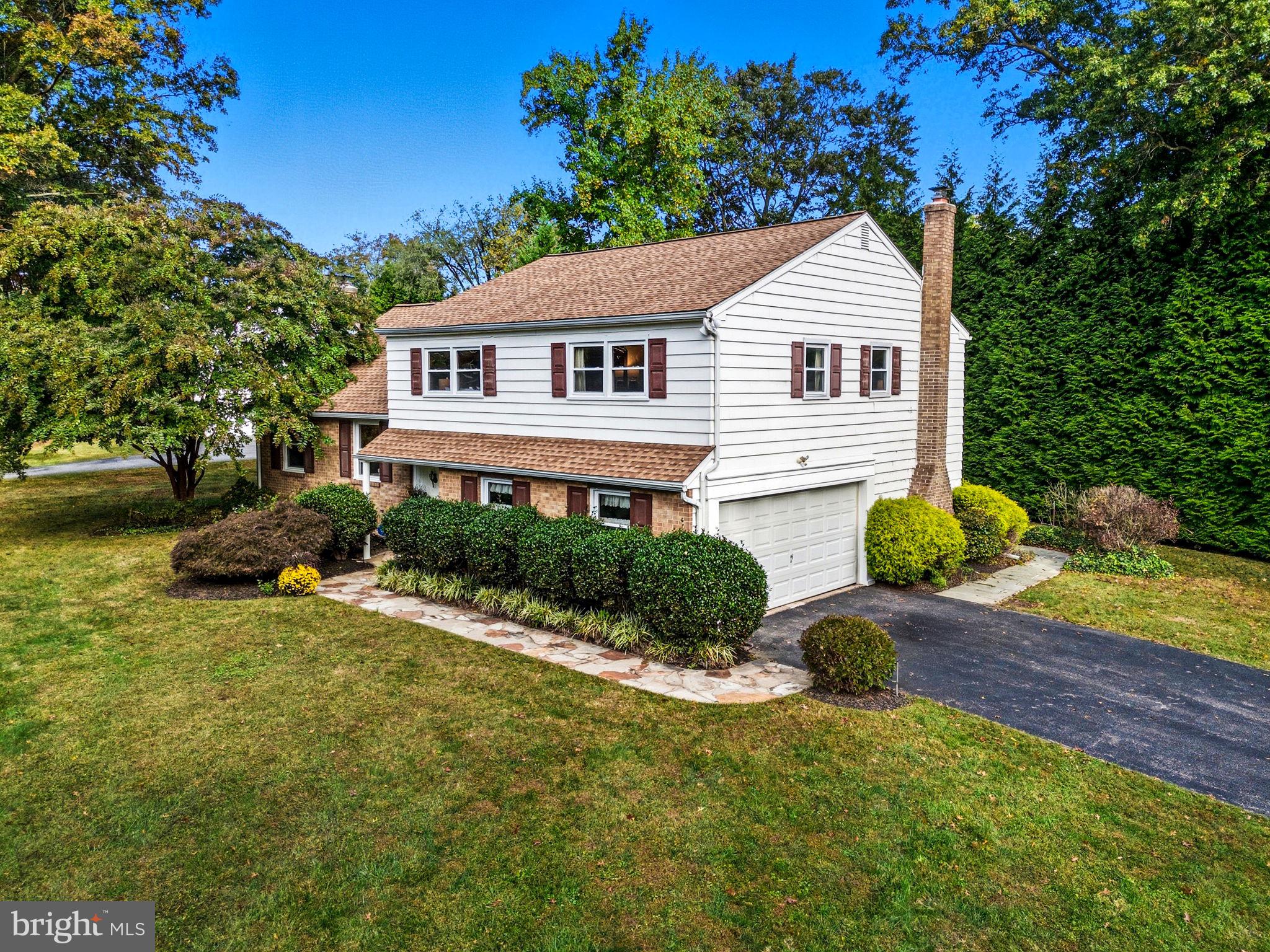 210 Cooper Drive Wallingford, PA 19086 - Photo 37 of 47 a front view of a house with a yard and garage