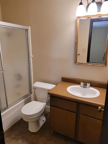 a bathroom with a toilet a sink and a mirror
