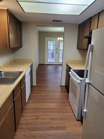 a view of a kitchen with wooden floor and electronic appliances