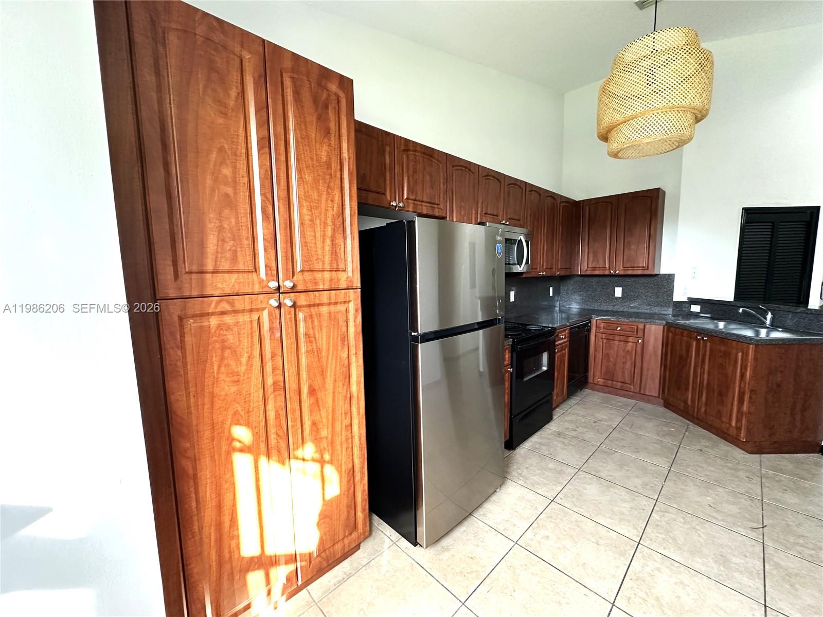 3550 Northeast 5th Street, Unit 202 Homestead, FL 33033 - Photo 13 of 23 a kitchen with stainless steel appliances granite countertop a refrigerator and a sink