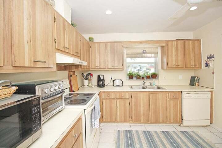 784 Nantucket Circle, Unit A Lake Worth, FL 33467 - Photo 11 of 30 a kitchen with granite countertop a sink white cabinets and stainless steel appliances