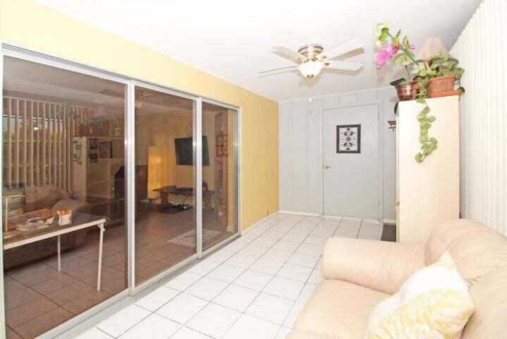 784 Nantucket Circle, Unit A Lake Worth, FL 33467 - Photo 14 of 30 a bedroom with a bed and a chandelier