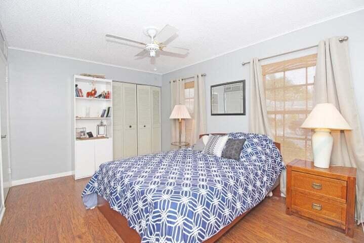 784 Nantucket Circle, Unit A Lake Worth, FL 33467 - Photo 19 of 30 a bedroom with a large bed and a chandelier