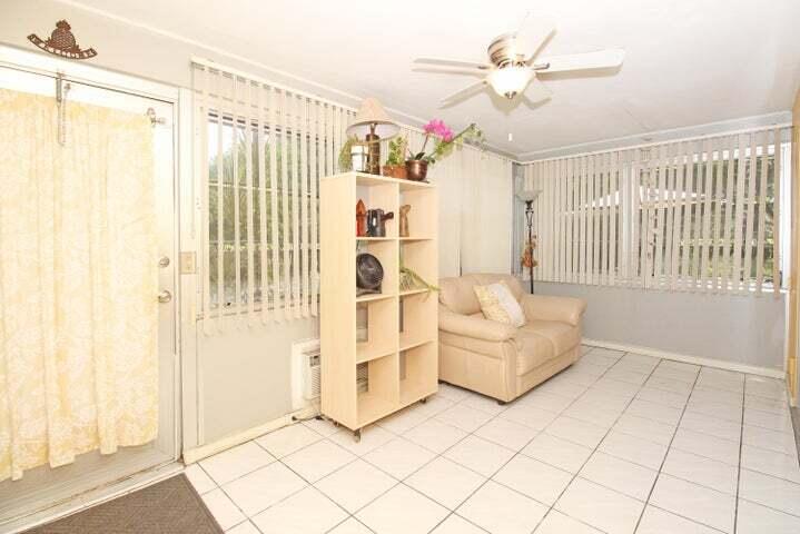 784 Nantucket Circle, Unit A Lake Worth, FL 33467 - Photo 4 of 30 a living room with furniture and a chandelier