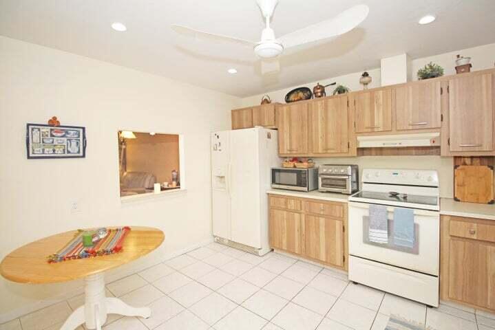 784 Nantucket Circle, Unit A Lake Worth, FL 33467 - Photo 10 of 30 a kitchen with stainless steel appliances granite countertop a refrigerator sink and white cabinets