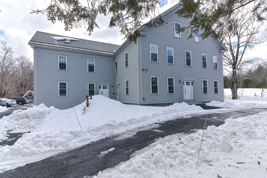 166 Littleton Road, Unit 1 Harvard, MA 01451 - Photo 22 of 23 a front view of a house with a yard covered in snow