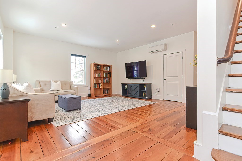 166 Littleton Road, Unit 1 Harvard, MA 01451 - Photo 6 of 23 a spacious bedroom with a large bed a flat tv screen and a bookshelf