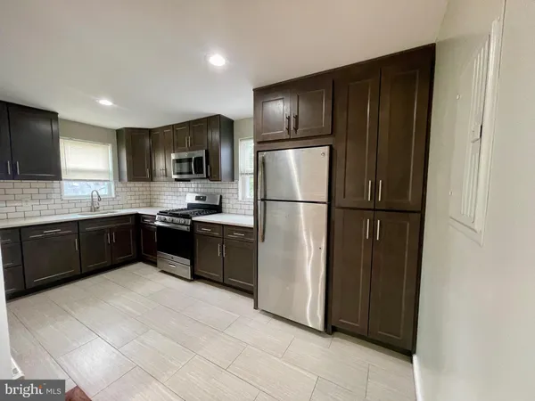 a kitchen with granite countertop stainless steel appliances a refrigerator and a sink