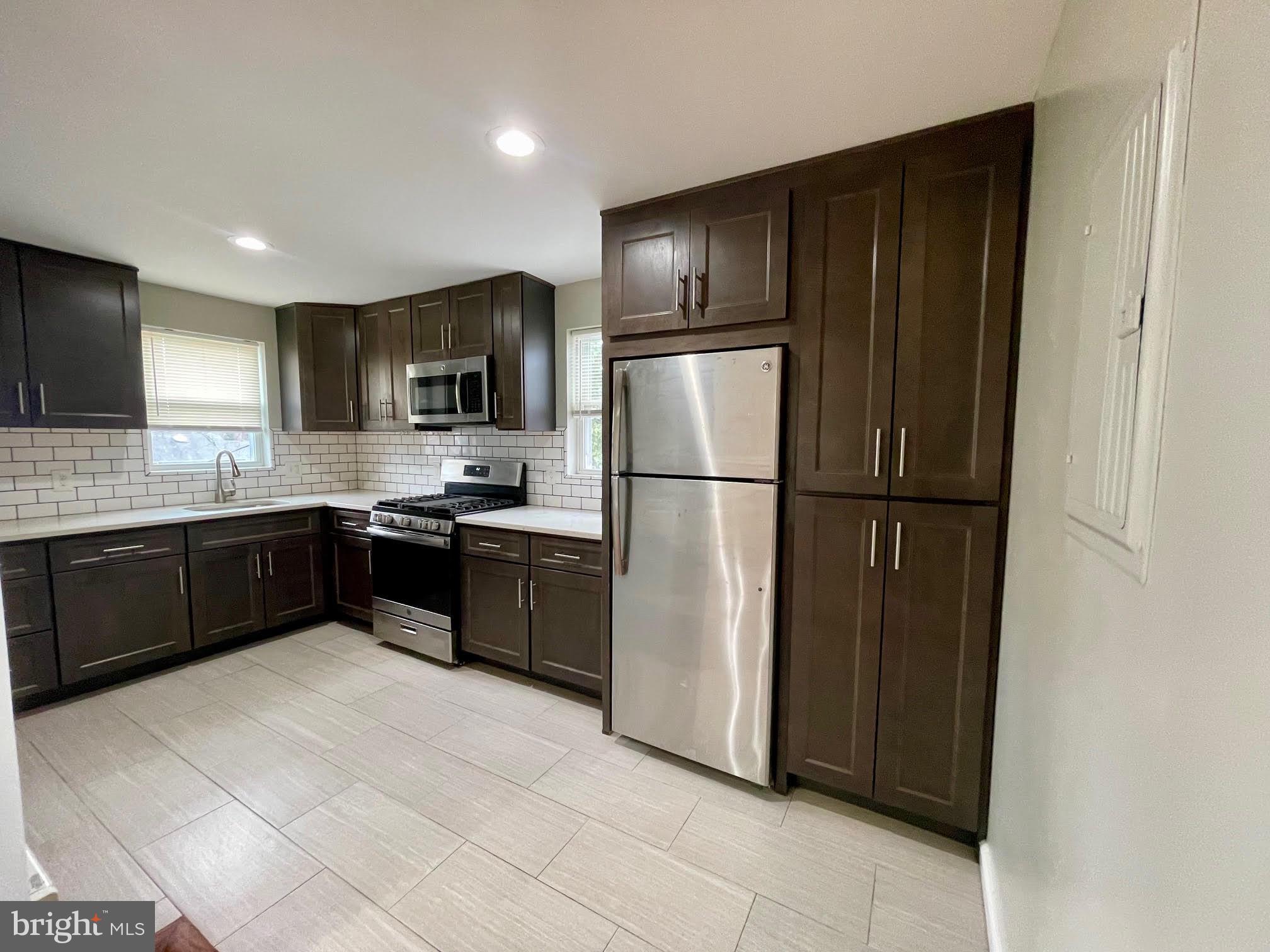 412 East Providence Road Aldan, PA 19018 - Photo 1 of 13 a kitchen with granite countertop stainless steel appliances a refrigerator and a sink