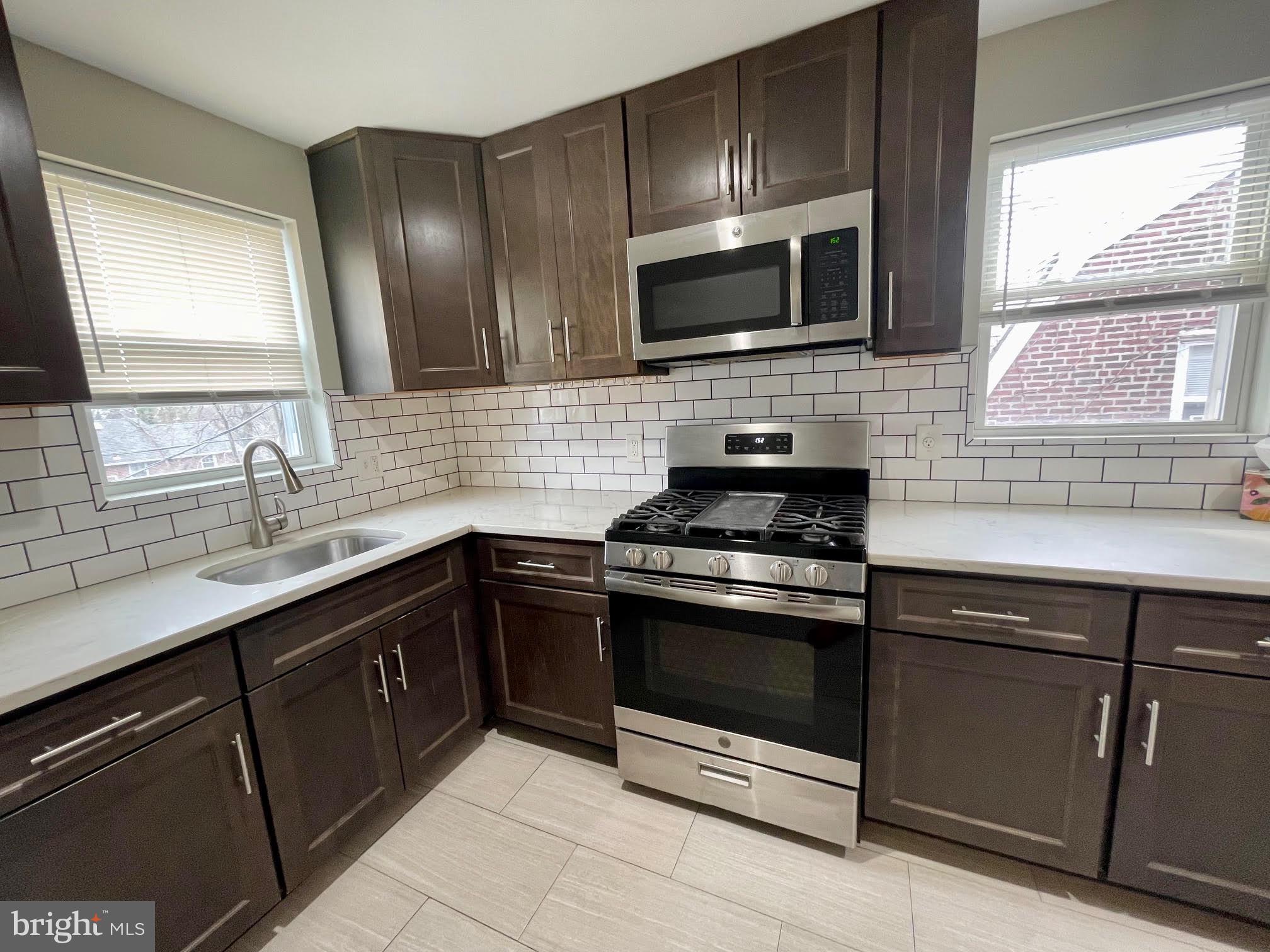 412 East Providence Road Aldan, PA 19018 - Photo 2 of 13 a kitchen with stainless steel appliances granite countertop a sink stove and microwave