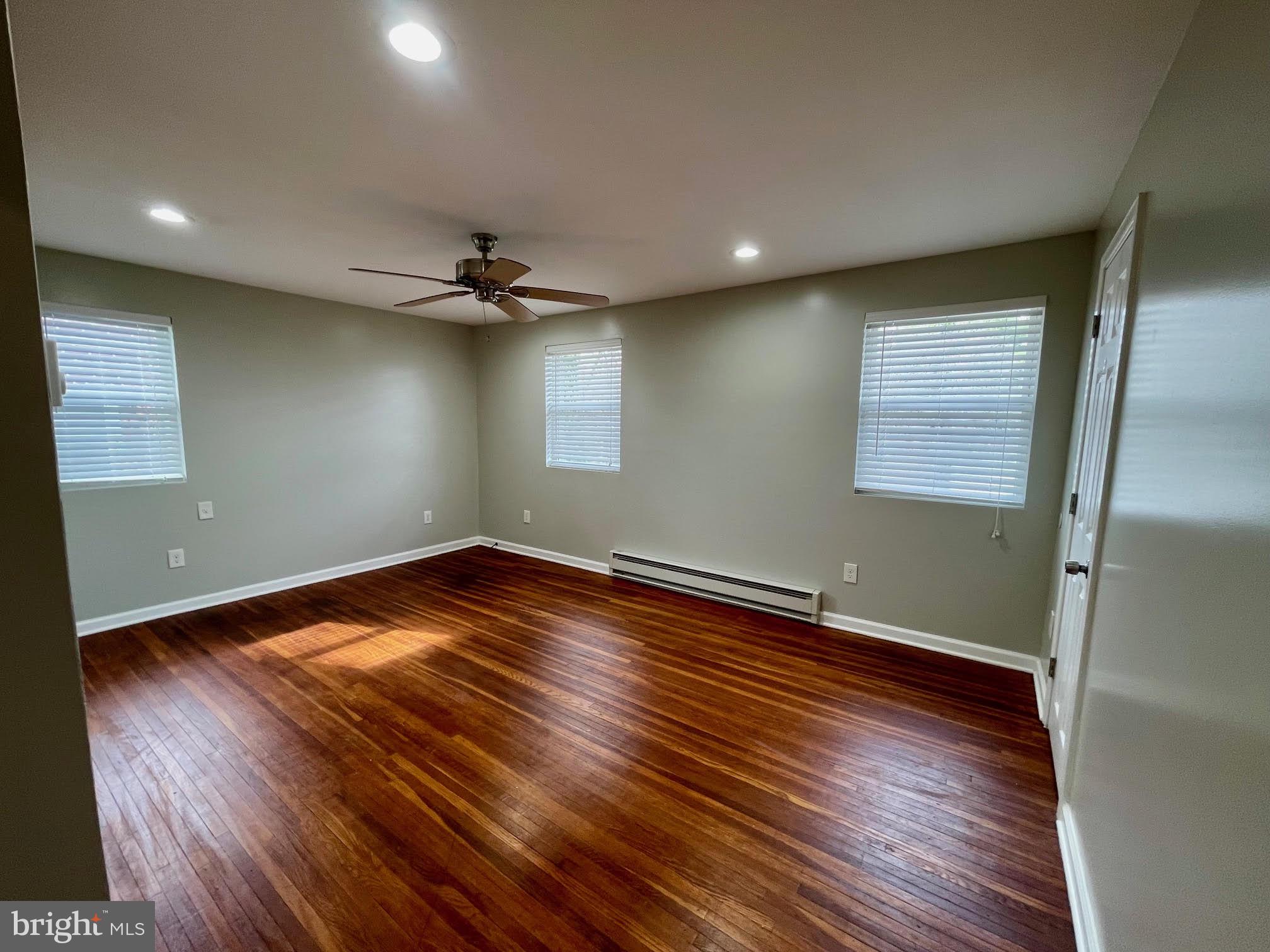 412 East Providence Road Aldan, PA 19018 - Photo 4 of 13 an empty room with wooden floor and a ceiling fan