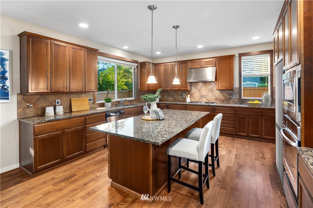 3714 215th Place Southeast Bothell, WA 98021 - Photo 13 of 37 a kitchen with granite countertop a stove a sink a dining table and chairs