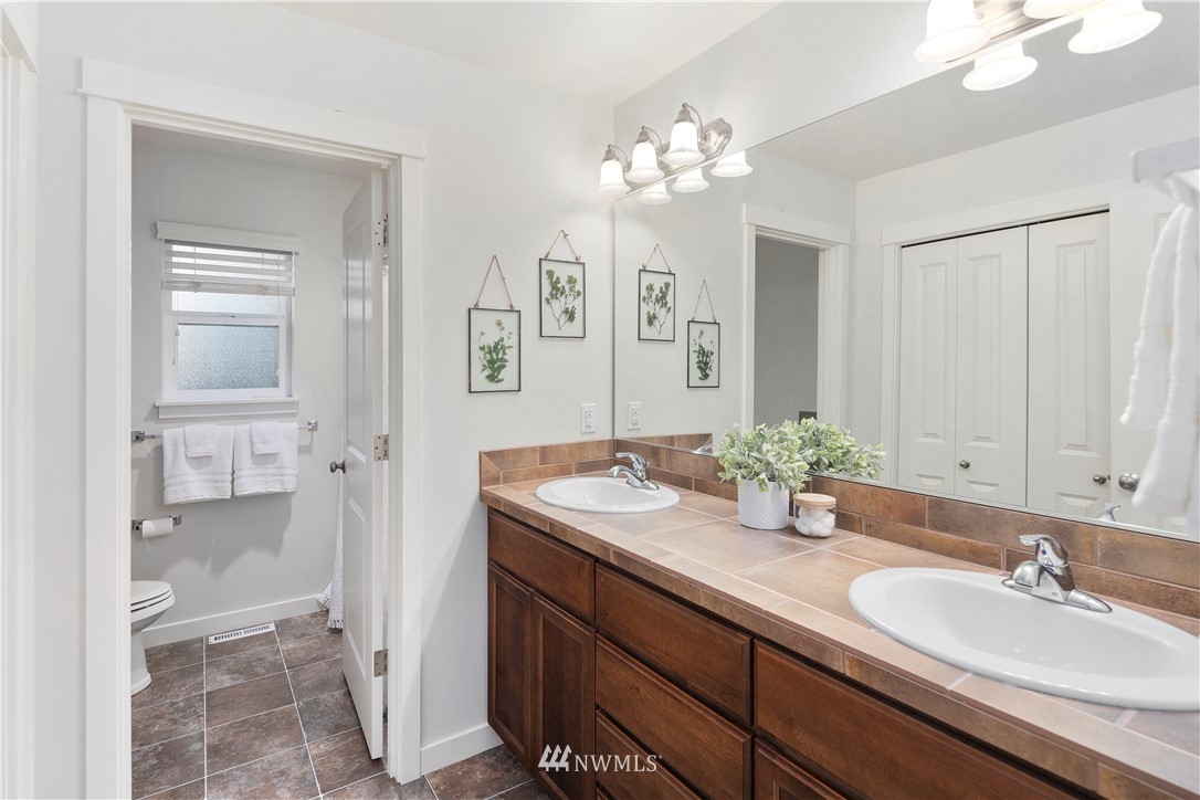 3714 215th Place Southeast Bothell, WA 98021 - Photo 29 of 37 a bathroom with a granite countertop sink a toilet and a mirror