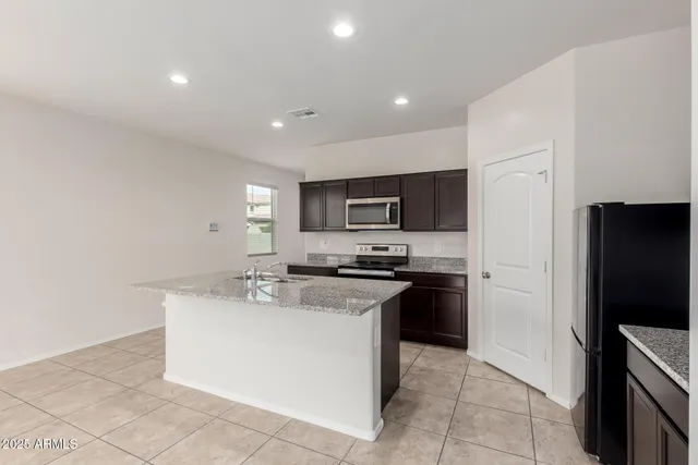 a kitchen with stainless steel appliances a sink stove and refrigerator