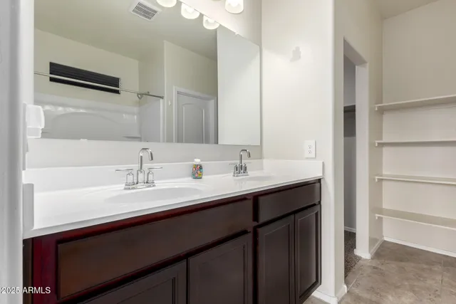 a bathroom with a sink double vanity and a mirror