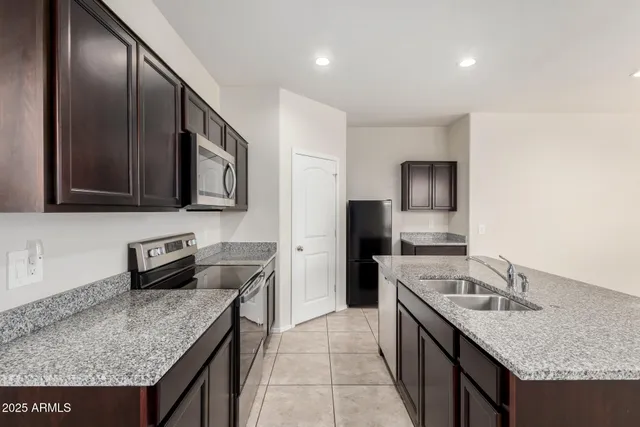 a kitchen with stainless steel appliances granite countertop a sink stove and refrigerator