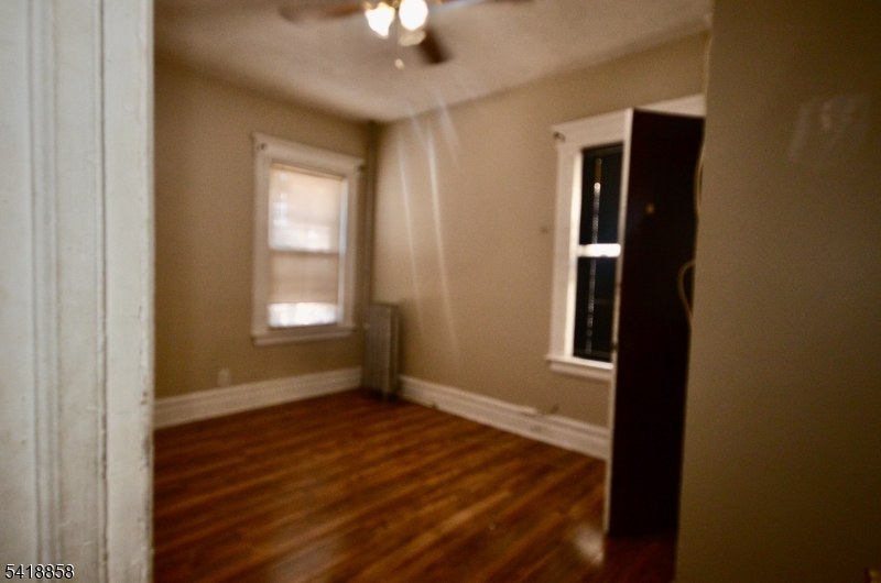 899 South 18th Street, Unit 1 Newark, NJ 07108 - Photo 21 of 23 an empty room with wooden floor cabinet and windows