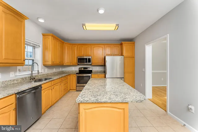 a kitchen with stainless steel appliances granite countertop sink stove and refrigerator
