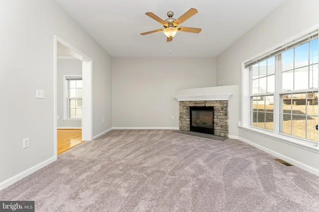 an empty room with windows and fireplace